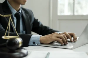 Divorce lawyer working on laptop at office desk with scales of justice and gavel, representing family law firm SEO services