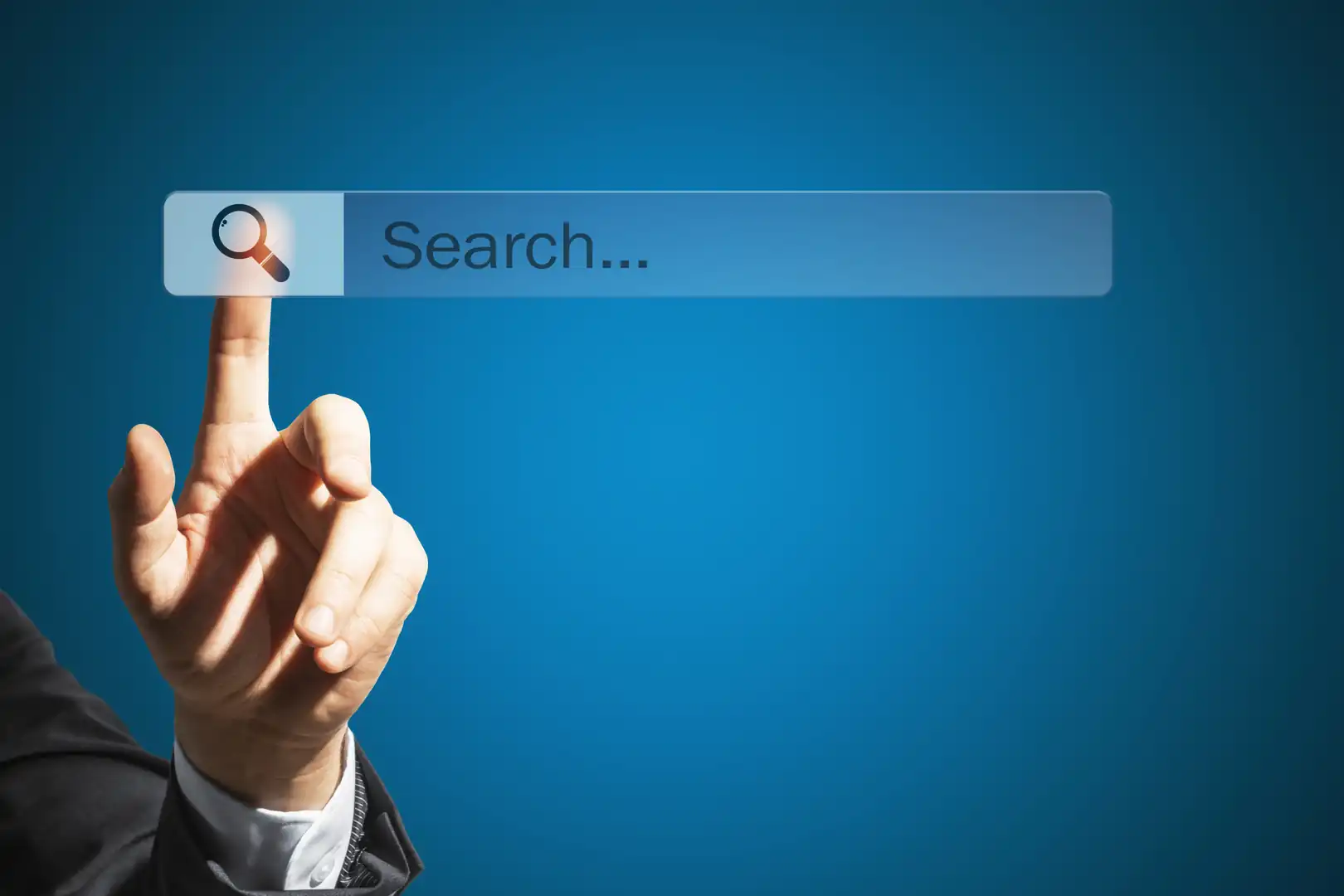 A person in a suit pointing a index finger at a translucent search bar with a magnifying glass icon on a blue background.